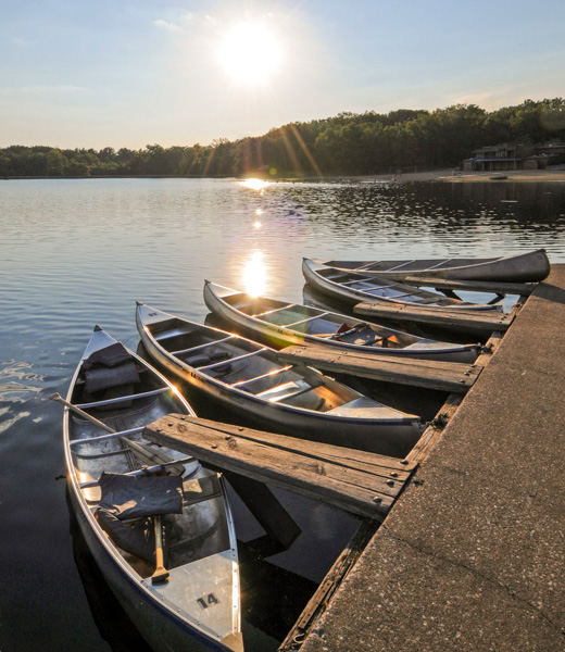 Empty canoes resting in the water 