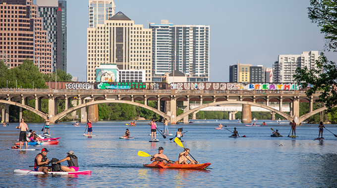 Stand-up paddleboarders navigate the calm waters at Lady Bird Lake. | Photo by Kenny Braun