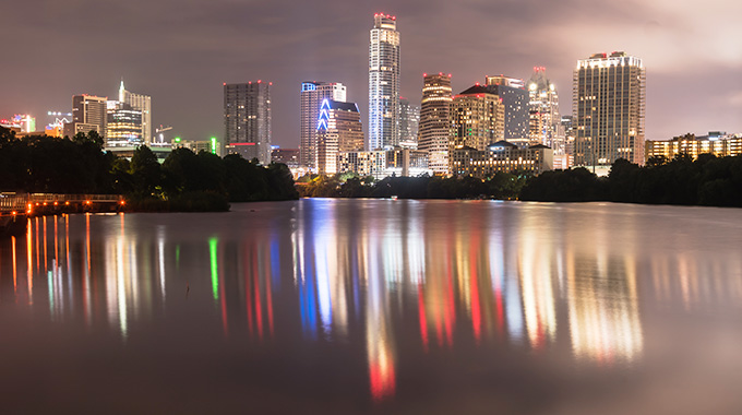 Downtown Austin's nighttime lights reflecting against the Colorado River