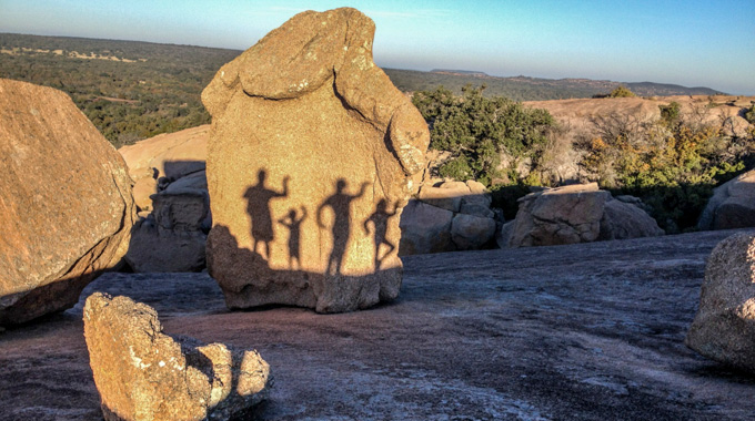 A family's shadows on Enchanted Rock.
