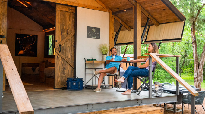 Couple sitting on porch outside a wood cabin