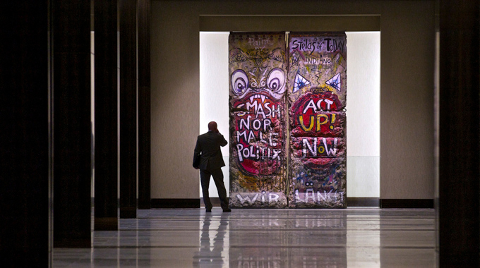 A visitor observing pieces of the Berlin Wall displayed at the Hilton Anatole