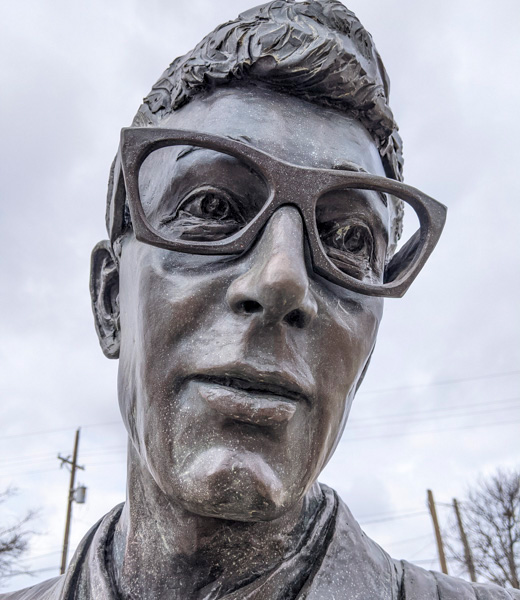 Close-up on the face of a Buddy Holly statue