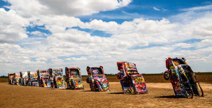 A line of old Cadillacs sticking up from the ground