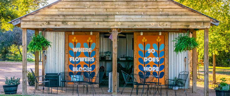 "Where flowers bloom, so does hope" painted on the Stonewall Motor Lodge barn doors 