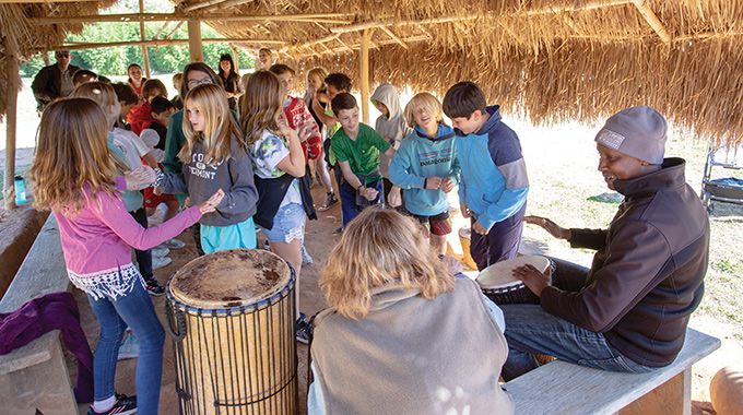 Jean-Claude Hatungimana drumming for a group of elementary school-age kids