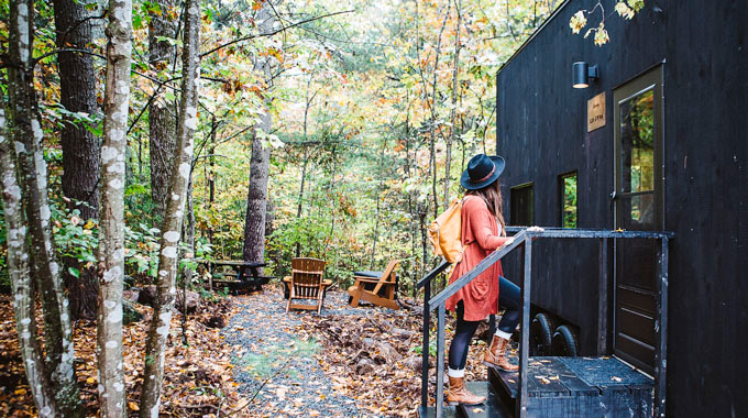 Woman standing outside a tiny cabin