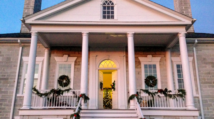 An illuminated Christmas tree waits beyond the open doors at Belle Grove