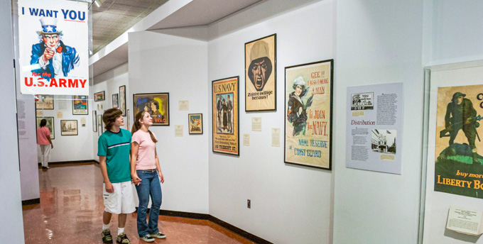 Couple holding hands while looking at posters inside the Virginia War Museum