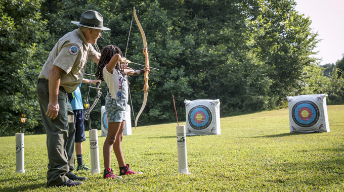 A Bear Creek Lake State Park ranger teaches a child how to use a bow during an archery lesson. | Courtesy Virginia Department of Conservation