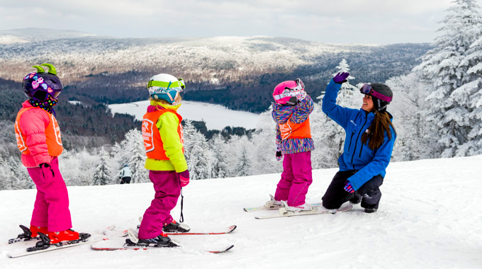 Young skiier high-fives an instructor at Snowshoe Mountain Resort