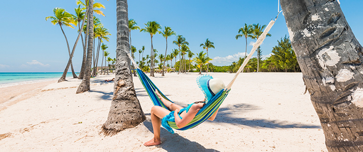 Woman relaxing in a hammock on the beach on a sunny day Woman relaxing in a hammock on the beach on a sunny day