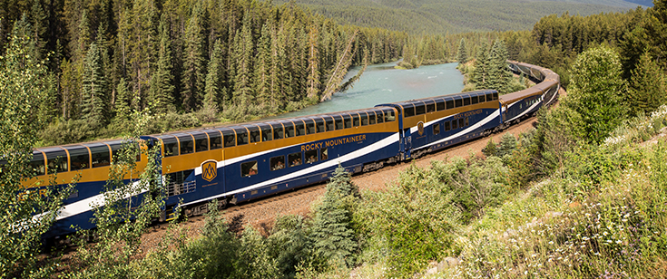 Rocky Mountaineer train traveling against trees Rocky Mountaineer train traveling against trees