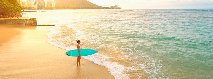 Girl standing on beach holding surf board Girl standing on beach holding surf board