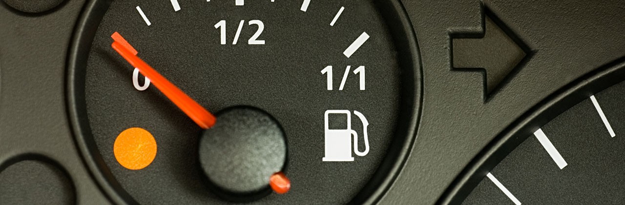 A gas gauge with the needle on empty and an illuminated "low gas" light