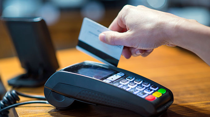 A credit card being swiped at a cash register