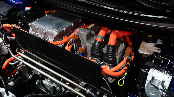 Under the hood of an electric car, with the electric motor and orange cables