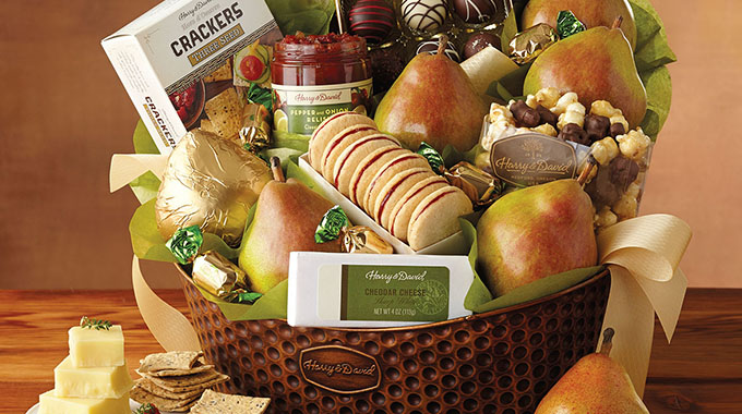A Harry & David gift basket arranged with crackers, fruits, cheese, and more