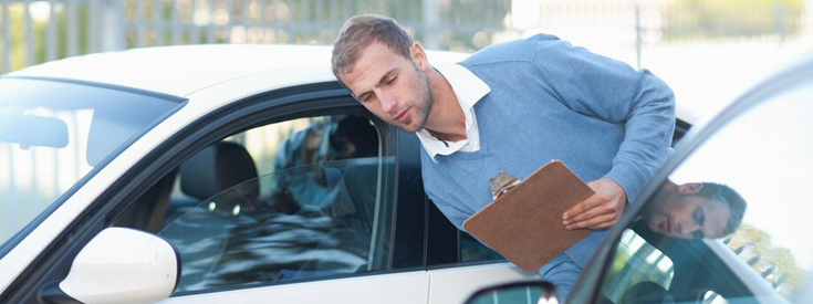 Claims adjustor looking at car damage Claims adjustor looking at car damage