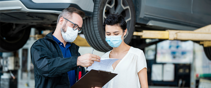 Mechanic woman masks car talking auto repair shop Mechanic woman masks car talking auto repair shop