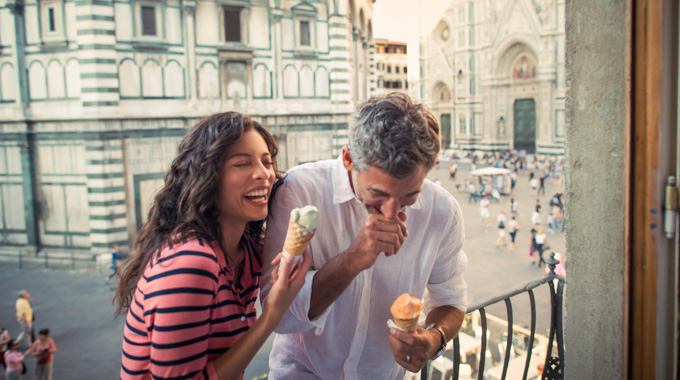 Couple enjoying a gelato on a balcony overlooking the streets of Florence
