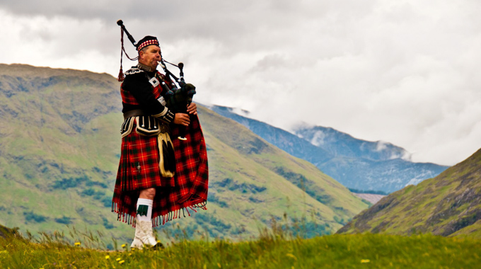 A bagpiper playing in the highlands