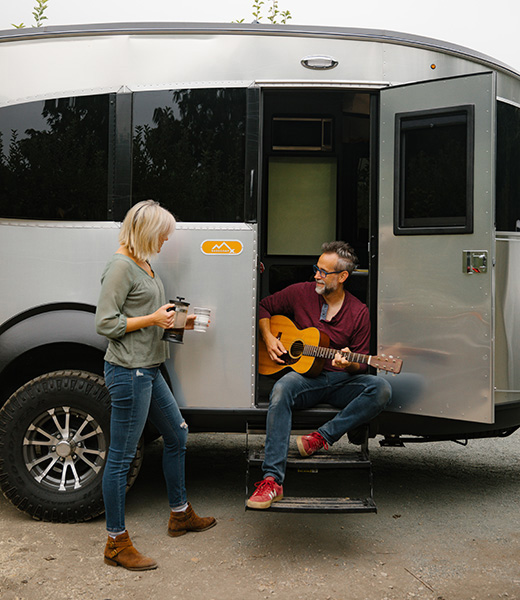 Starshine enjoys a cup of coffee while John plays his guitar outside the Airstream.  