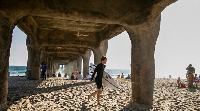 Surfers walking beneath Manhattan Beach Pier