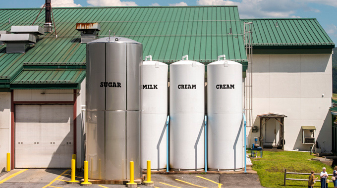 Giant silos labeled with their contents: sugar, milk, and cream