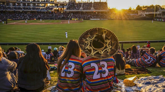 Isotopes' fans dressed in mariachi-themed jerseys watching a game from The Berm.
