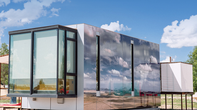 El Cosmico micro home, with mirrored walls reflecting the surrounding landscape.
