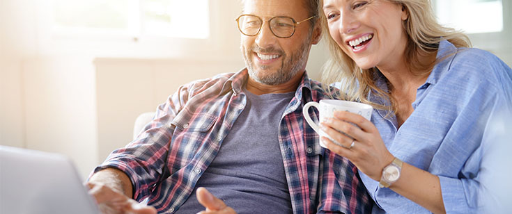 Couple looking at laptop together Couple looking at laptop together
